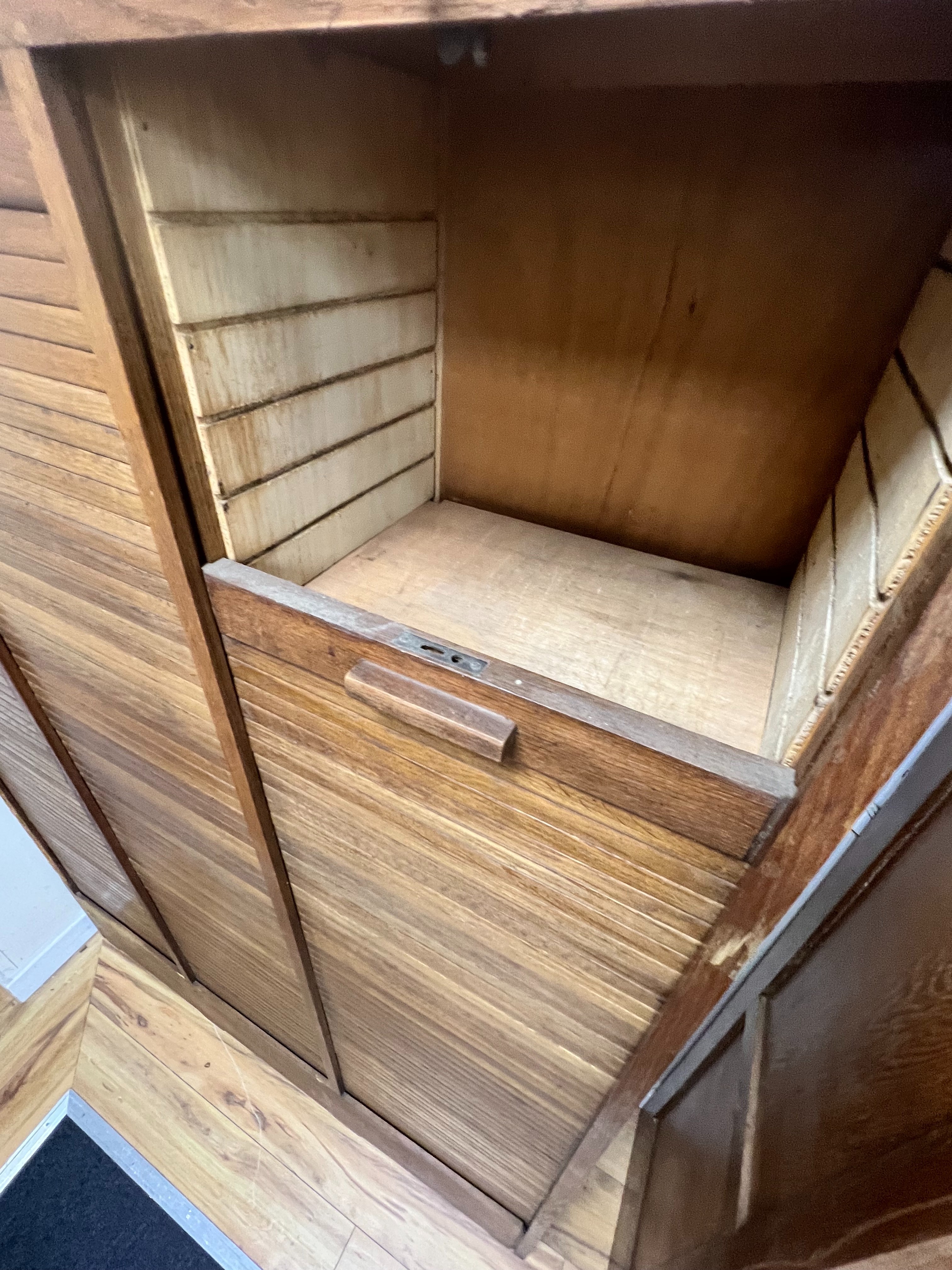 A mid century oak triple tambour filing cabinet, width 129cm depth 37cm height 180cm